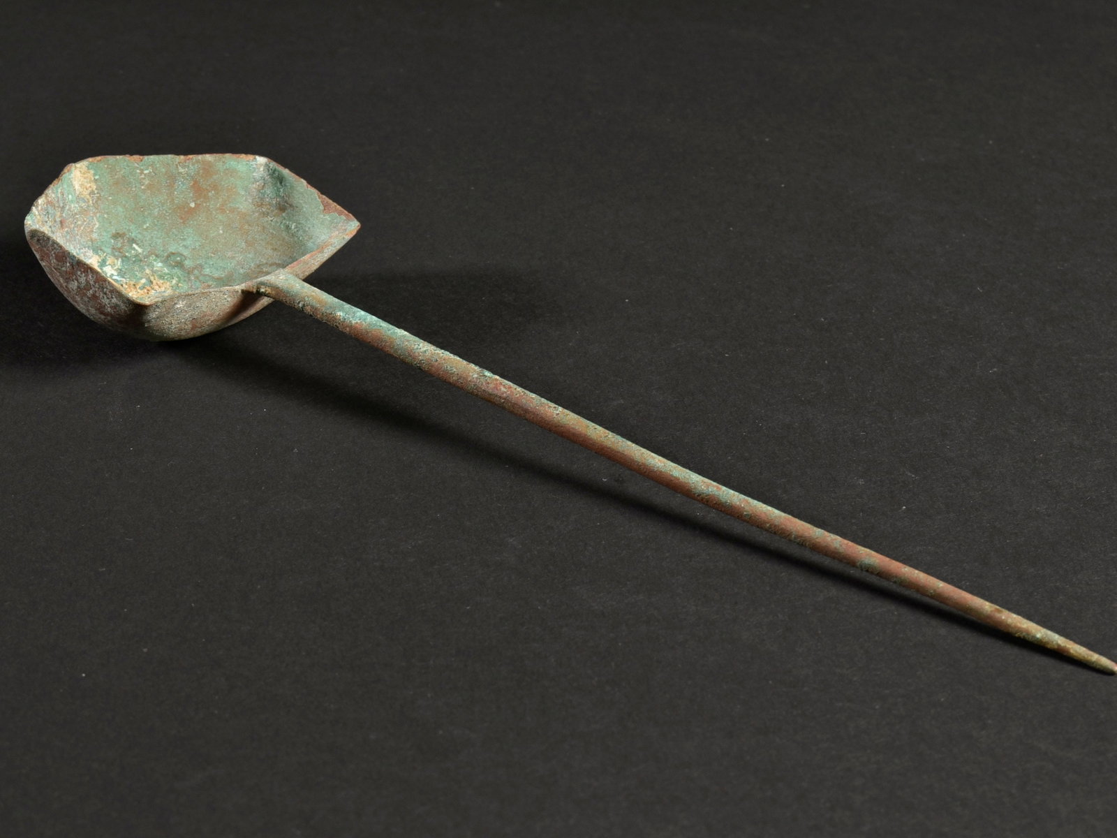 A Western Asian Pentagonal Bronze Spoon / Asian Art: Fünfeckiger Löffel Westasien Ohne Sockel / without base Kupferlegierung. B 6,5 cm L 23 cm Provenienz: - Herbert A. Cahn, Basel (1990er Jahre). - Hammer Auktionen, Basel (15.06.2019, Lot 118). -