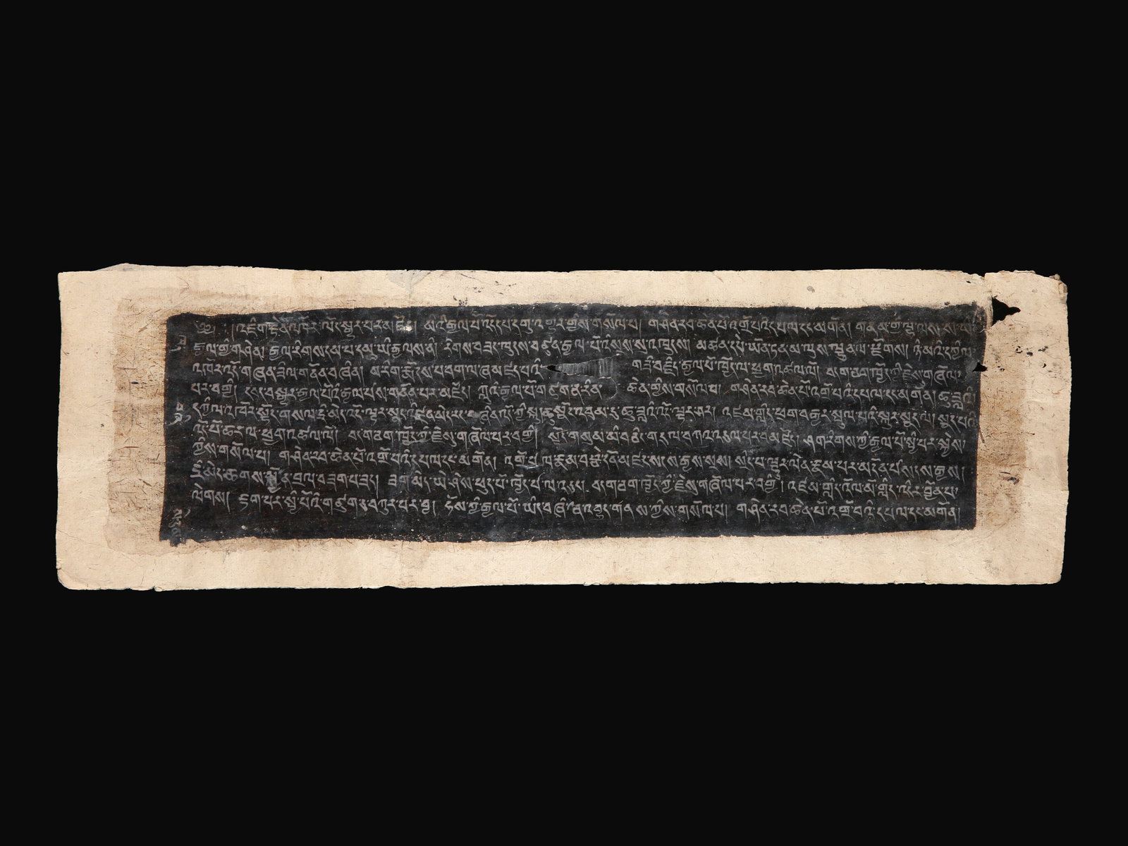 A Tibetan Manuscript Leaf from a Buddhist Sutra: Manuskriptblatt aus einem buddhistischen Sutra Tibet Ohne Sockel / without base Maulbeerpapier. B 16 cm. L 51 cm. Provenienz: - TimeLine Auctions, Harwich, 02.12.2020, Lot 1667. - Schweizer Privatsamm