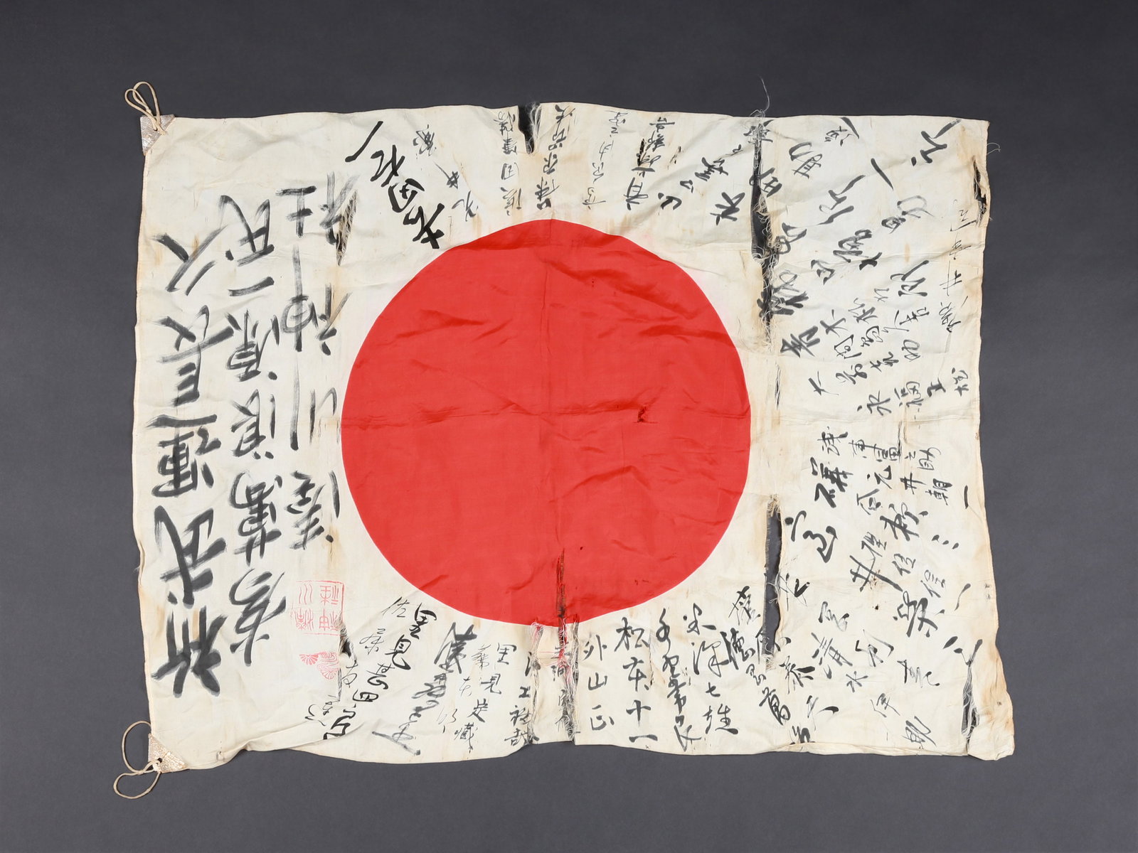 A Japanese Good Luck Flag from WWII, "yosegaki hinomaru": Glücksflagge, 2. Weltkrieg, "yosegaki hinomaru" Japan Ohne Sockel / without base Seide. B 66 cm. L 85 cm. Provenienz: - Donley Auctions, Auction Sale 109, June 2020. - Schweizer Privatsammlung, Basel