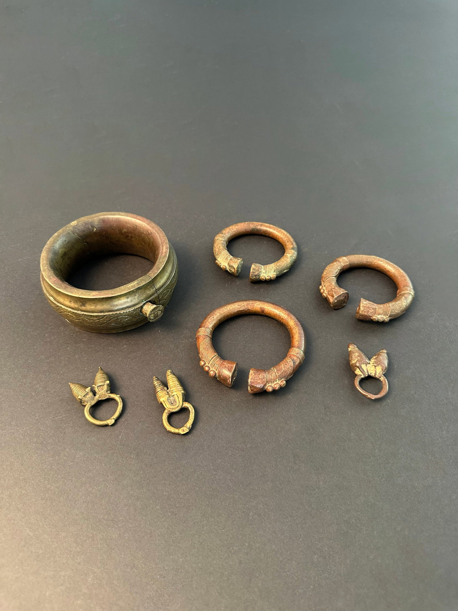 3 Dogon Pendants, 3 Bangles and an Anklet: 3 Anhänger, 3 Armreife und ein Fussreif Dogon. Mali Ohne Sockel / without base Gelbguss. H Ringe: ca. 4,5 cm Provenienz: - Galerie Walu, Zürich (vor 1999). - div. Hammer Auktionen, Basel. -