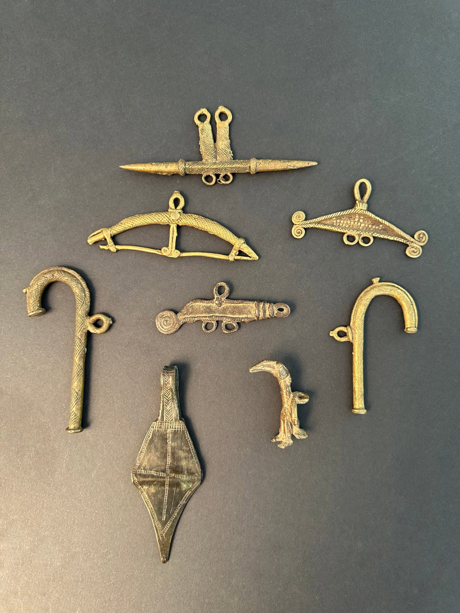 8 Amulets (Bronze Pendants): 8 Amulette (Schmuckanhänger) Gurunsi / Lobi / Tusian / Tuareg. Burkina Faso / Niger Ohne Sockel / without base Gelbguss. L 5,5 - 14,5 cm. Provenienz: - René David (1928-2015), Zürich.