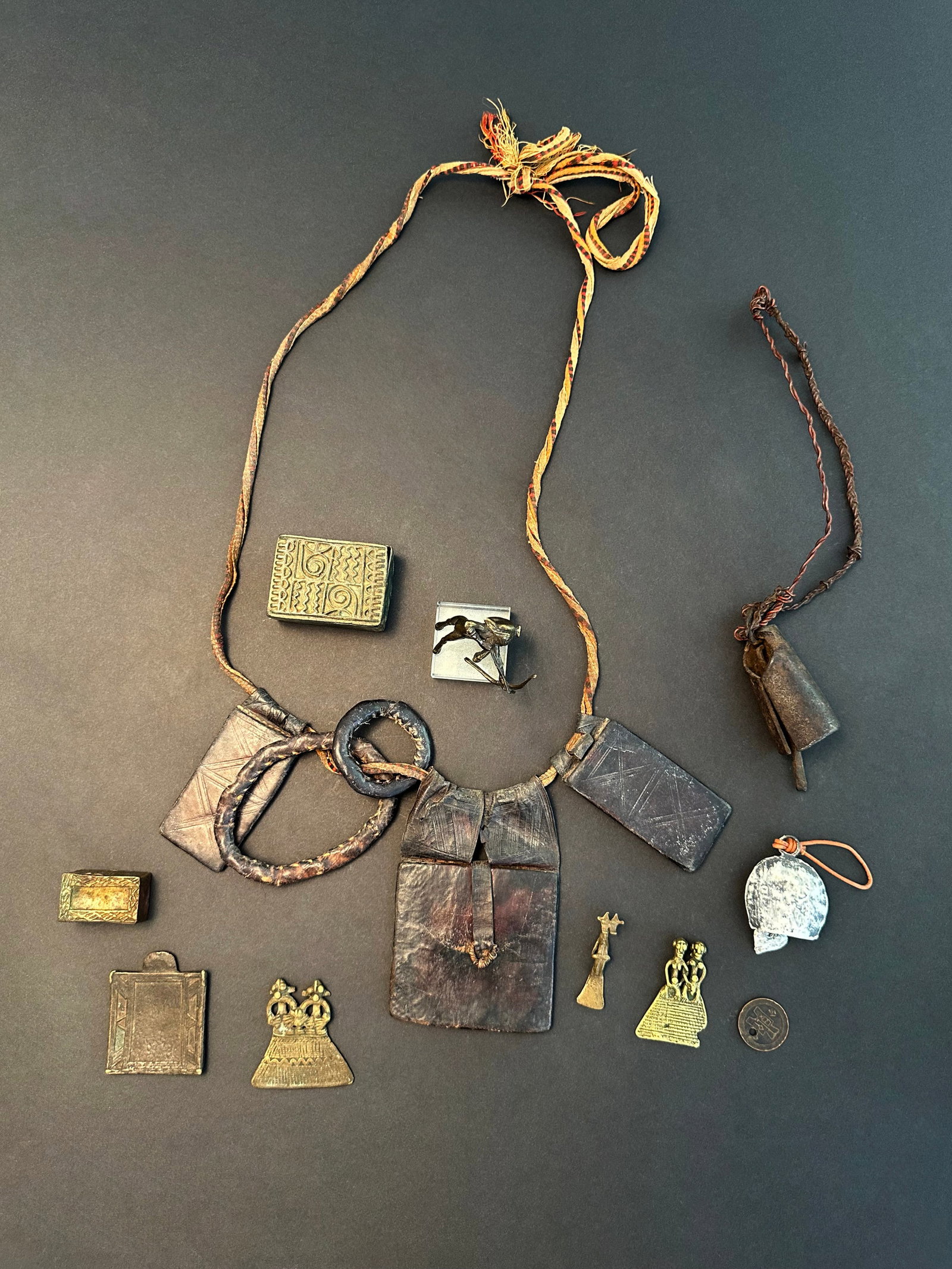 A Lot consisting of 9 Westafrican Artifacts: Lot bestehend aus 9 Artefakten Mit einem Sockel / with one base Gelbguss, Eisen, Leder. L 2,5 - 5,5 cm. Provenienz: - div. Hammer Auktionen, Basel. - Claudine und Christoph Eichele (1952-2020 &