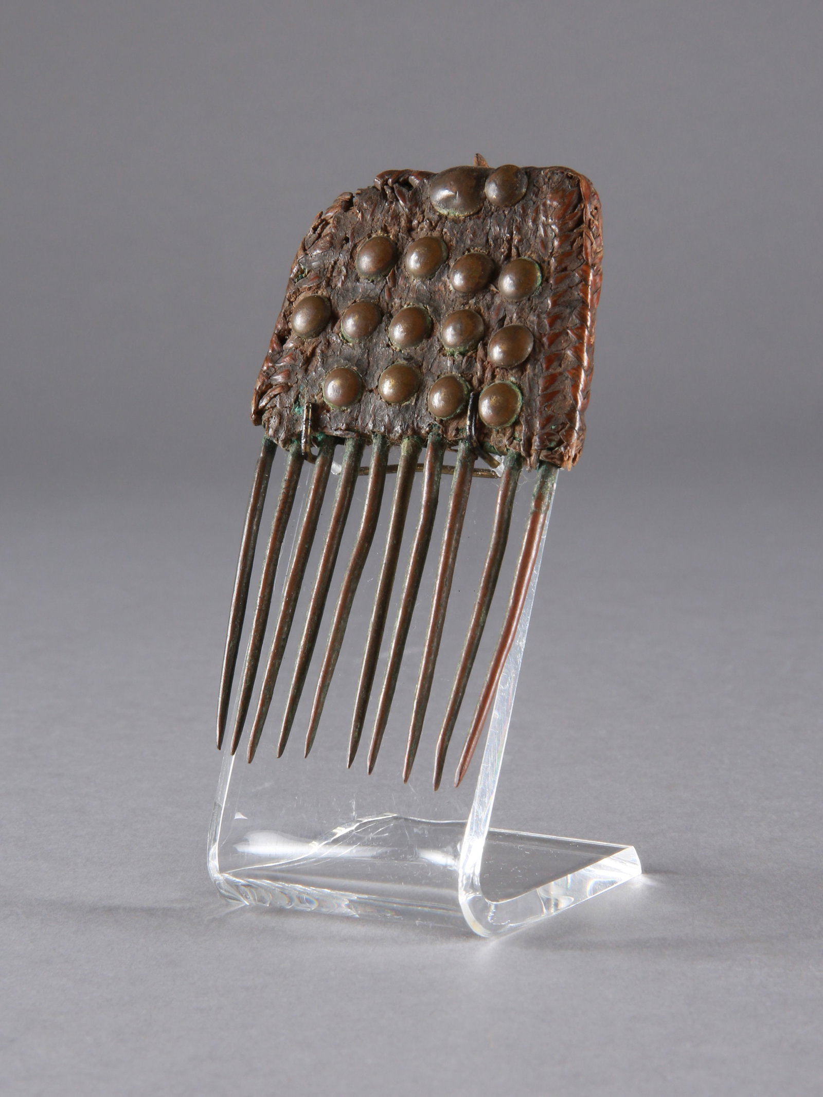 An Akan Copper Comb: Kupferkamm Akan. Ghana / Côte d’Ivoire Mit Sockel / with base Kupfer, Palmblatt, Polsternägel. H 7,5 cm. Provenienz: - Denise Zubler (1928-2011), Zürich. - Hammer Auktionen, Basel