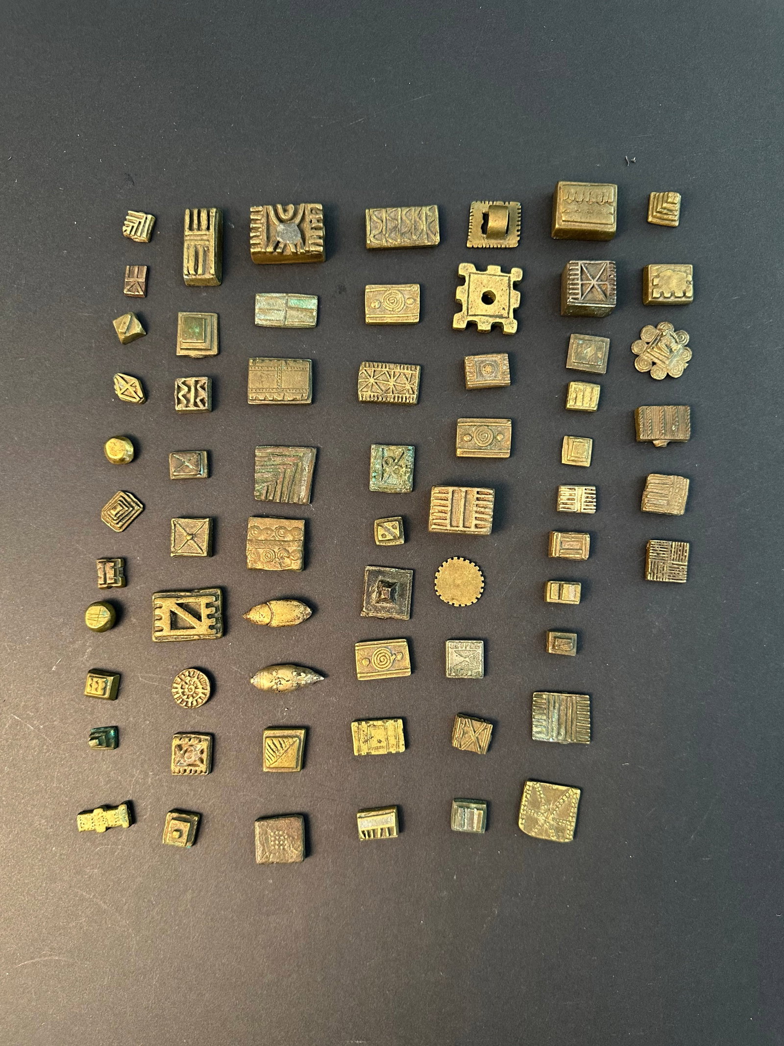 64 geometric Asante Gold Weights: 64 geometrische Goldgewichte Asante. Ghana Ohne Sockel / without base Gelbguss. L 1 - 3,5 cm. Provenienz: - div. Hammer Auktionen, Basel. - Claudine und Christoph Eichele (1952-2020 & 1949-2026),