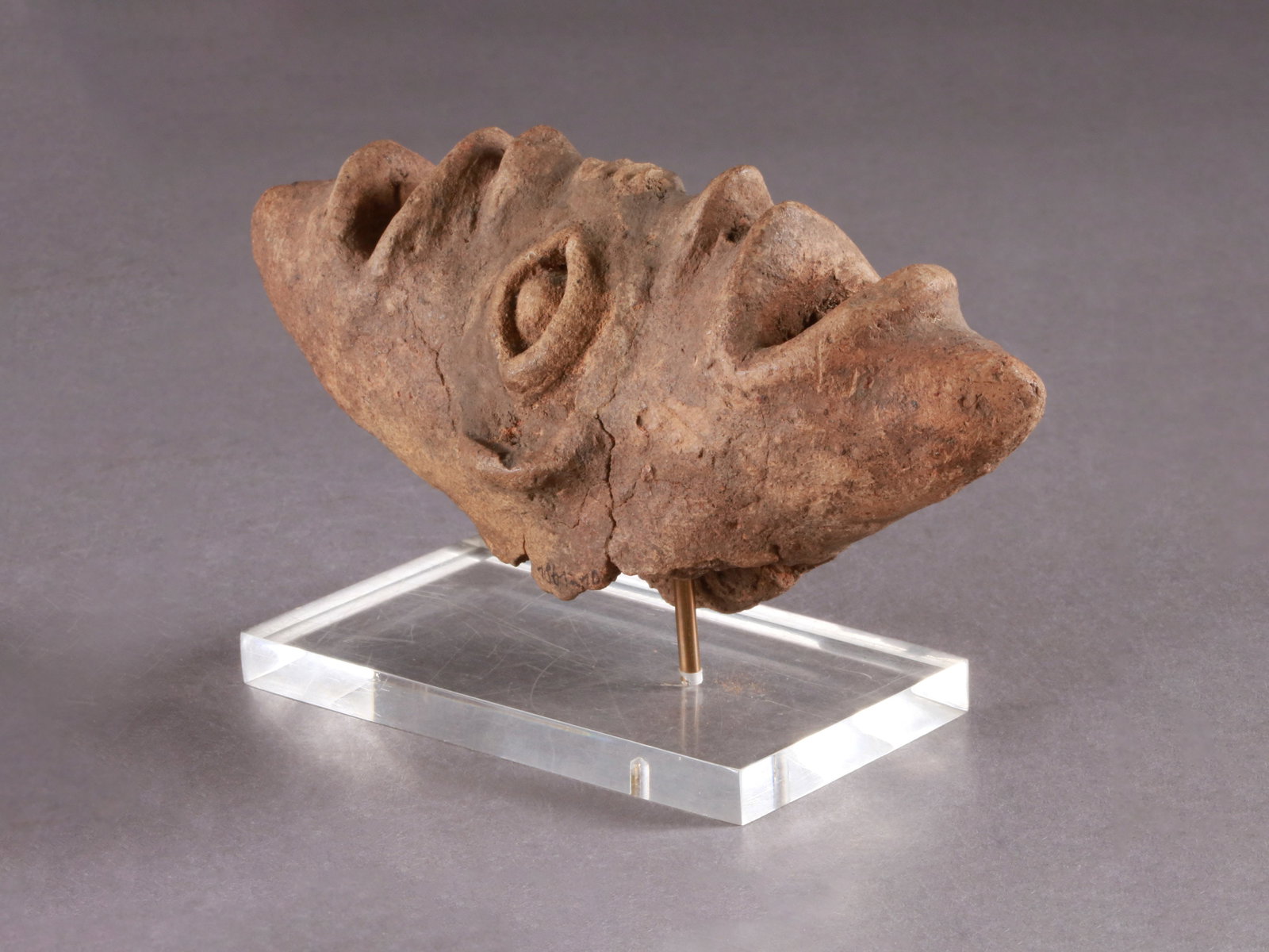 A Koma-Bulsa janiform Head, "kronkronbua": Janusförmiger Kopf, "kronkronbua" Koma-Bulsa Kultur. Ghana Mit Sockel / with base Terrakotta. H 7 cm. L 14,5 cm. Provenienz: Galerie Walu, Zürich (vor 1987). Publiziert: Schädler, Karl-
