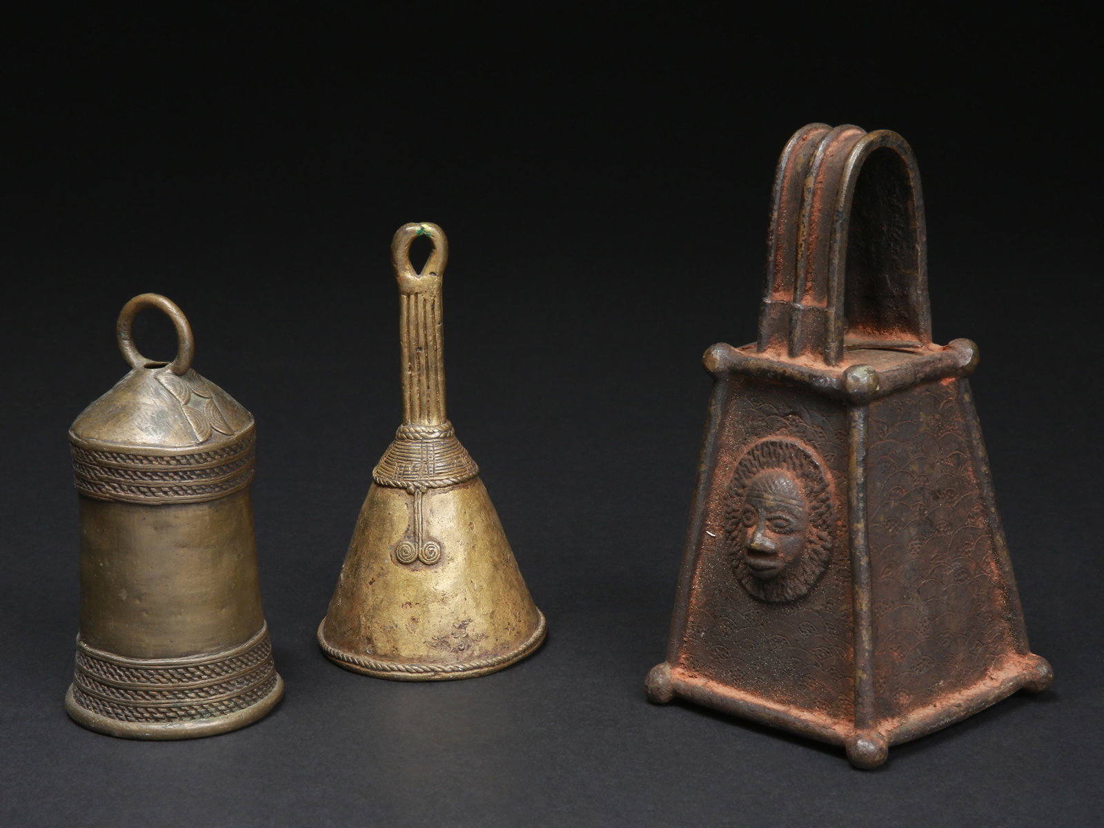 3 Nigerian Ceremonial Bells: 3 Zeremonialglocken Nigeria Ohne Sockel / without base Gelbguss, Eisen. H 12,5 -17,5 cm. Provenienz: Schweizer Privatsammlung (in situ erworben). Glocken sind Klanginstrumente, die in
