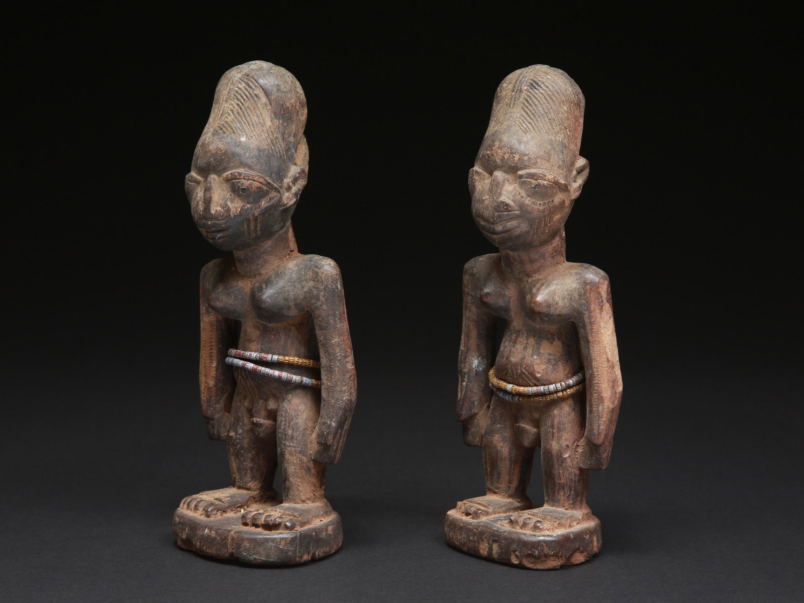A Yoruba Pair of Twin Figures, "ere ibeji": Zwillingsfigurenpaar, "ere ibeji" Yoruba. Nigeria Ohne Sockel / without base Holz, Glasperlen. H 23 - 23,5 cm. Provenienz: Schweizer Privatsammlung (in situ erworben). Gesegnet oder verwünscht er