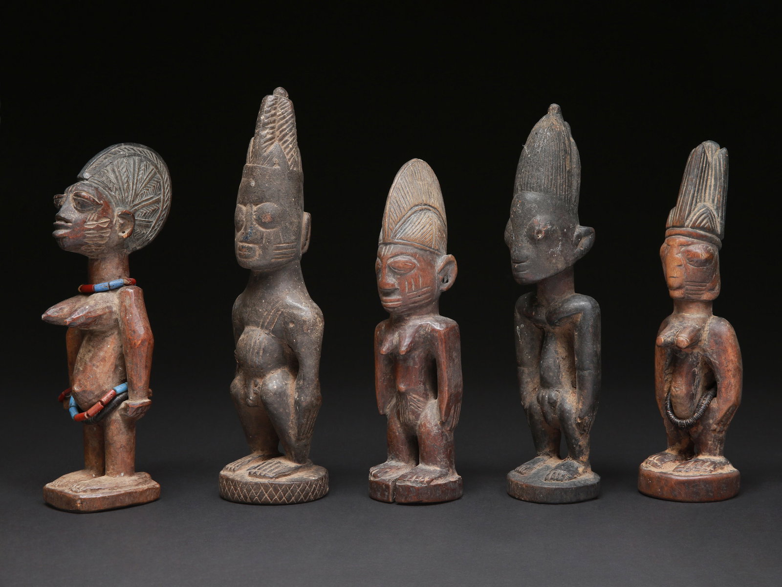 5 Twin Figures, "ere ibeji": 5 Zwillingsfiguren, "ere ibeji" Yoruba. Nigeria Ohne Sockel / without base Holz, Glasperlen. H 25 - 30 cm. Provenienz: Schweizer Privatsammlung (in situ erworben). Gesegnet oder verwünscht ersche