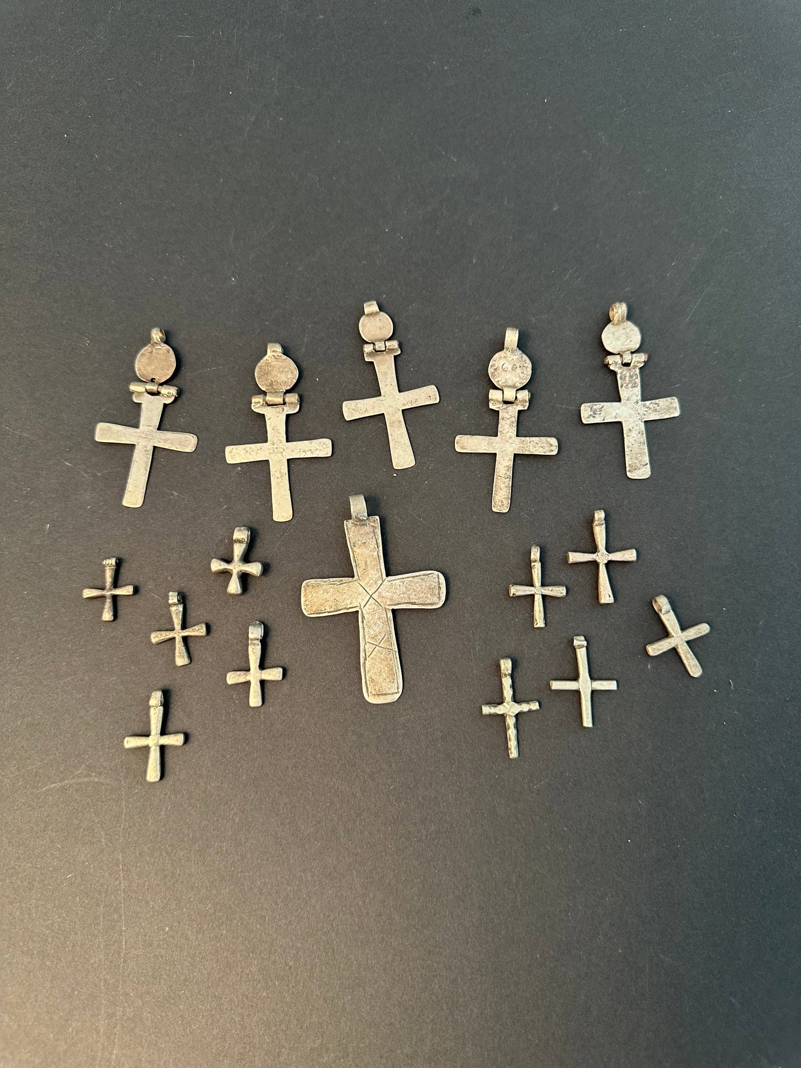 16 Ethiopian Silver Crosses, "yangat masqal": 16 Silber-Kreuze, "yangat masqal" Äthiopien Ohne Sockel / without base Silber. H 2 - 7 cm. Provenienz: - Schweizer Privatsammlung, Vitznau. - Hammer Auktion 51, Basel, 08.04.2020, Lot 98 und