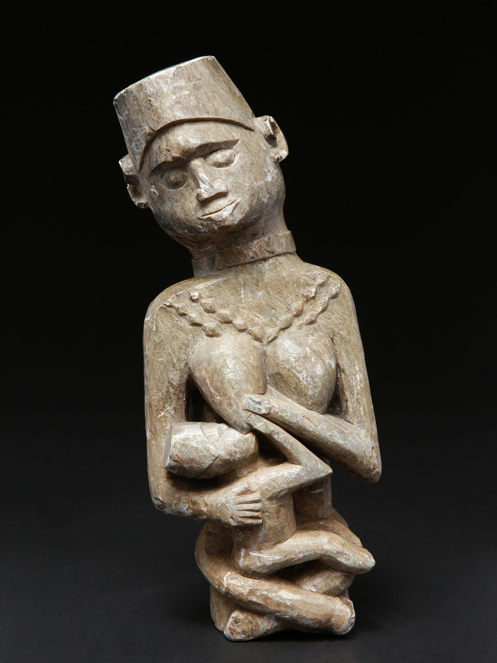 A Kongo-Mboma Maternity Figure, "Ngudi a muana / Mwalakazi": Mutter-Kind Figur, "Ngudi a muana / Mwalakazi" Kongo-Mboma. Angola Ohne Sockel / without base Stein. H 28 cm. Provenienz: - Ernst Hauswedell Kunstauktionen, Hamburg, 07.06.1961, Lot 551. - Ernst