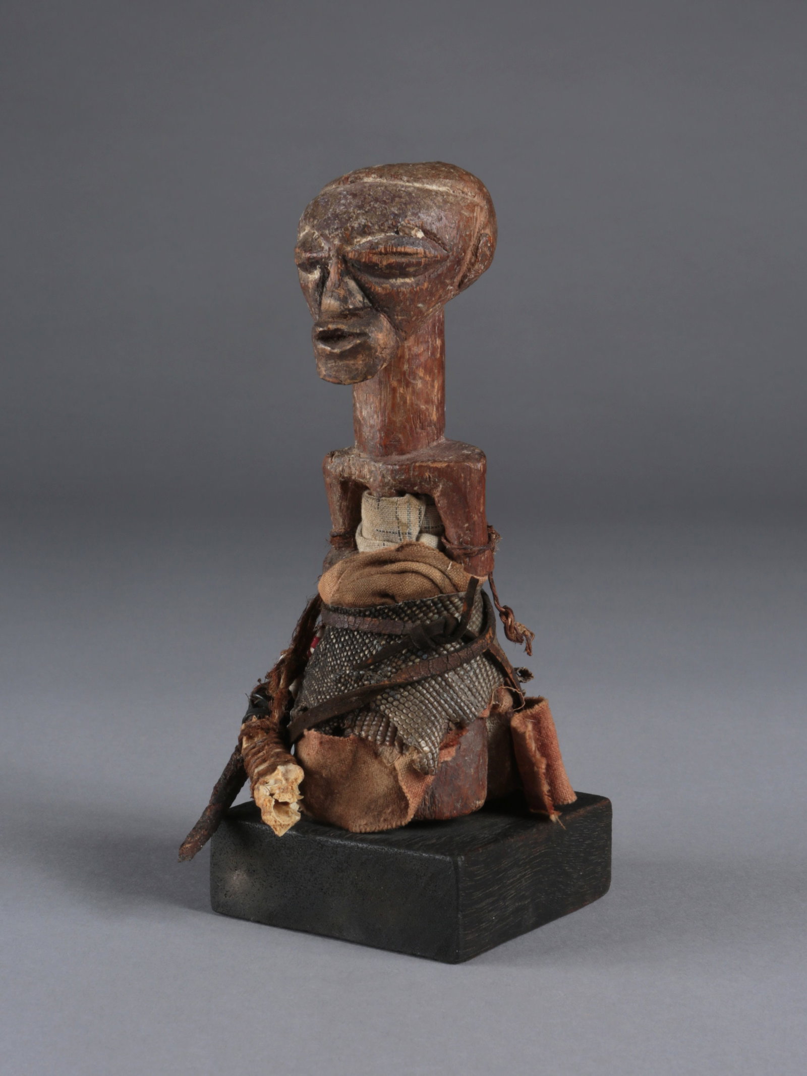 A Tetela Miniature Figure,"nkisi": Miniaturfigur,"nkisi" Tetela. DR Kongo Mit Sockel / with base Holz, div. Fetischmaterial. H 15,5 cm. Provenienz: - Kunstauktionshaus Zemanek-Münster, Würzburg (26.11.2015, Lot 449). -