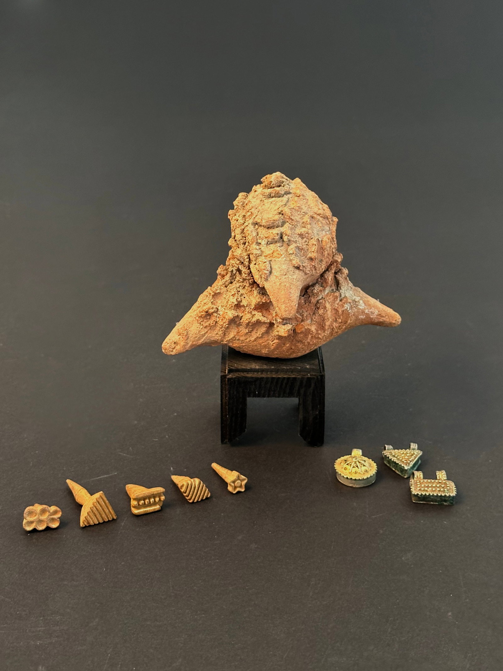 A Terracotta Artifact, 3 Amulets and 5 Stamps: Ein Terrakotta-Artefakt, 3 Amulette und 5 Stempel Longuda. Nigeria, Äthiopien, Indonesien (?) Mit einem Sockel / with one base Terrakotta, Holz, Silberlegierung. H 2,5 - 11 cm. Provenienz: