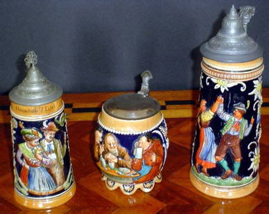 THREE SCENIC GERMAN BEER STEINS 1 w/ MUSIC BOX 12655: Three custom scenic German beer stein. Small one with music box Dimensions: Various Sizes Age: C. 1910 Material: Porcelain