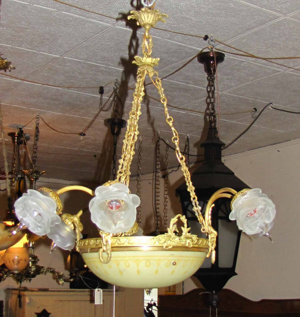 6 ARM DORE BZ CHANDELER W/ CTR GLASS DOME 15610: 6 arm gold Dore bronze chandler with ram heads, wreath crowns, 6 small flowered shades, and a pale-yellowish green center dome. Dimensions: 27"h x 26"w Age: 1910 Material: Bronze and Glass