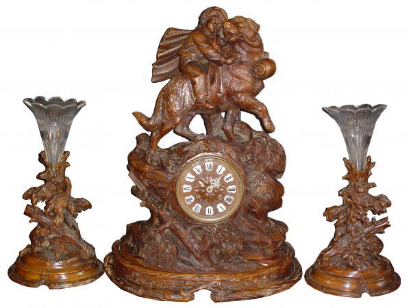 QUALITY ST BERNARD BLACK FOREST CLOCK SET 15774: Museum quality three piece Black Forest clock set with boy riding Saint Bernard with barrel collar and side tree motif epergnes. Dimensions: Clock: 22.5"H x 16.5"W x 9"D Age: 1890 Material: Carved woo