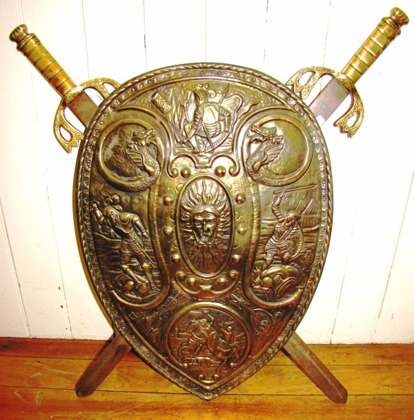 CROSS SWORD SHIELD W/ KNIGHTS & DRAGONS 14543B: Cross sword shield w/ knights, dragons, & center head Dimensions: Age: Material: