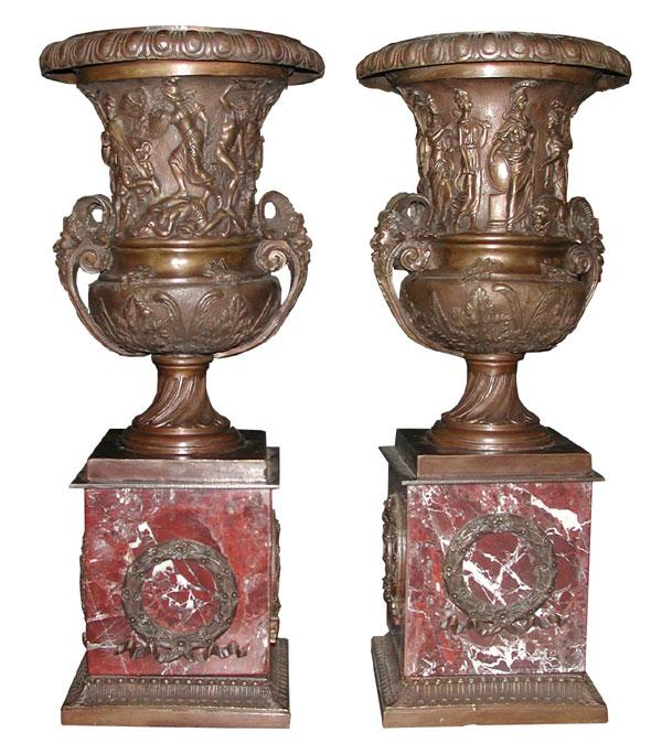 HIGH RELIEF CAST BZ URNS OF EGYPTIANS (4124): Elaborate high relief Cast Bronze urns of Egyptians with Pan formed handles sitting upon rouge marble base with bronze floral wreath & ribbon bottom. Dimensions: 18.75"H x 8"Dia Age: 1930 Material: Ca