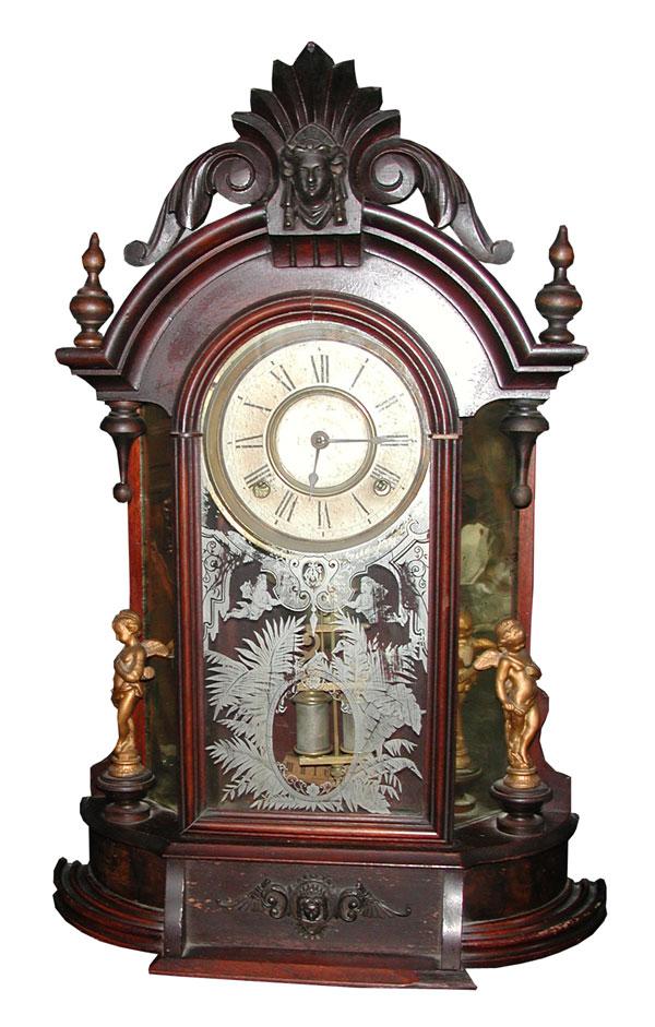 ANSONIA VICTORIAN WALNUT CLOCK W/SIDE MIRRORS 4120: Ansonia Victorian Walnut clock w/ side mirrors, winged cupids, & Jenny Lind Head crest. Dimensions: 24"H x 16"W x 5.5"D Age: 1880 Material: Walnut