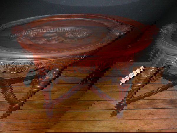 CVD MAHOGANY TEA TBL W/CVD MERMAID&HORN TOP 4175: Carved Mahogany tea table with carved top of mermaid blowing horn under removable glass tray with wood handles. Dimensions: 20.5"H x 30.5"W x 19"D Age: 1920 Material: Mahogany & Glass