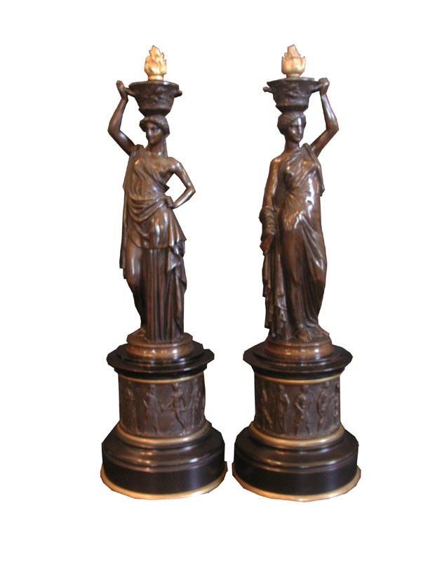 PAIR EMPIRE BRONZE LADIES HOLDING FLAMED URNS 1779: Decorative pair of bronze Empire ladies holding flamed urn on black marble base with figural frieze. Marked.LVE.Robert Dimensions: 19.5"H x 6.5"Dia Age: 1820 Material: Bronze & marble