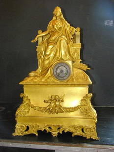 LG EARLY GILT BZ MANTEL CLOCK OF ROYAL WOMAN 1548: Exceptional Early gilt bronze oversized mantel clock of Royal woman sitting on throne with staff in hand on top & has cupid adorned floral garland accented base. Dimensions: 29"H x 18.5"W x 1"D Age: 1