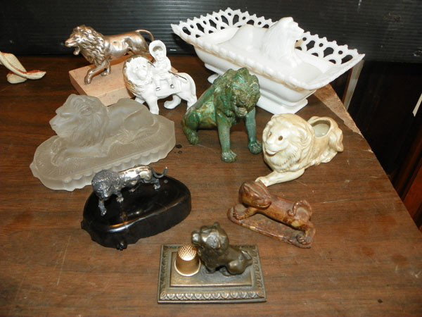9 MISC SM LION STATUES - GLASS, CHINA & BRONZE 2184: Nine miscellaneous lion statues including butter dish and thimble holder. Dimensions: Assorted. Age: Assorted. Materials: Glass, China, Bronze etc.