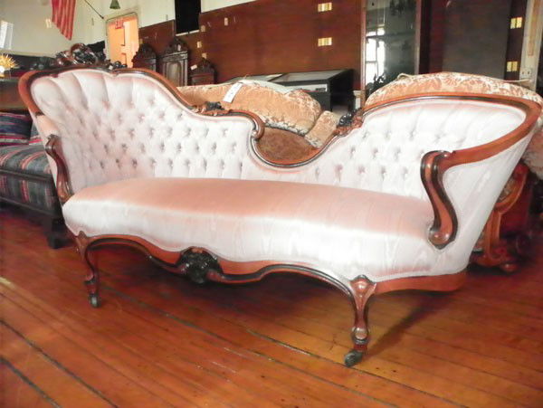 VICTORIAN WALNUT CHAISE LOUNGE W/PINK UPHOSTERY 20: Victorian walnut chaise lounge 2 tone with nut floral carvings and pink tufted upholstery. Dimensions: 41 1/2"H x 78"W x 28"D Age: C.1860 Material: Walnut and Fabric
