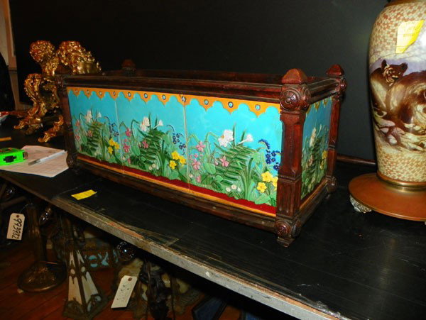 CARVED WOOD PLANTER WITH SIGNED MINTON TILES 2259: Fully tiled carved wood planter with signed Minton tiles in vibrant floral motif. Eight tile surround. Dimensions: 11 1/2"H x 25 1/4"W x 10 1/2"D Age: C.1870 Material: Wood and Tile