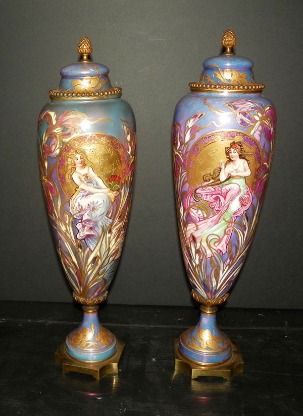 SGND DUROY ART NOUVEAU URNS W/ LADIES 2232: Elaborate signed Duroy Han painted Art Nouveau urns with beautiful ladies in purple iridescent background with gold accents. Dimensions: 18.5"H x 5.5"Dia Age: C 1890 Materials: Porcelain and Cast Bron