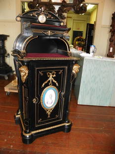 VICTORIAN MUSIC CABINET BZ HEADS PORC. PLAQUE 2092: Incredible ebonized and gold incised bronze mounted single door music cabinet with lady and winged cupid porcelain plaques bronze lady heads and two tiered shelf top. Dimensions: 57.5"H x 25"W x