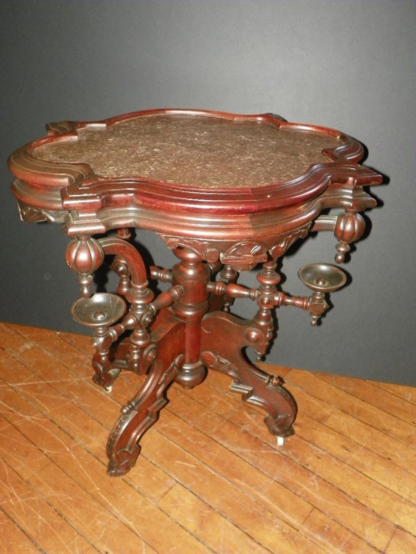 FINE RENAISSANCE MARBLE TOP CENTER TABLE 2071: Elaborate American Renaissance carved Walnut center table uniquely designed with side holders, oversized finials, inset turtle top and elaborate spindle work. Dimensions: 31"H x 30"W x 24"D. Age: C 18