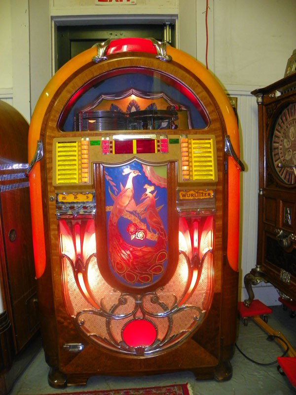 RARE ORIGINAL WURLITZER 850 PEACOCK JUKE BOX 2001: A tremendously rare find! This amazing original Wurlitzer 850 Peacock featuring two center peacock plaques, plays 78's with water bubbling sides and exceptionally designed top with chrome accents and 