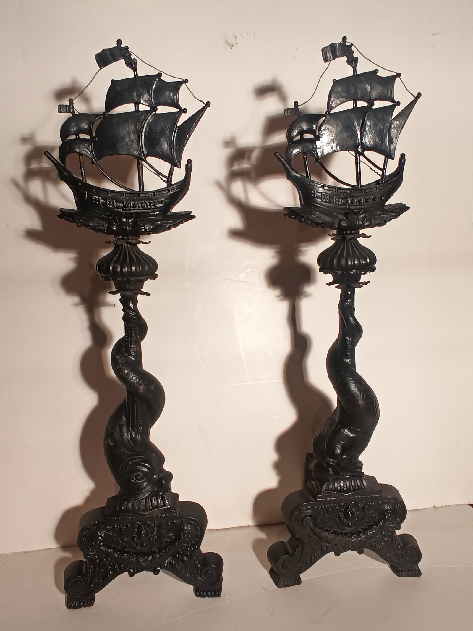 Nice antique pair of iron twist tail dolphin andirons with ship tops having bronze sails 36" tall: Nice antique pair of iron twist tail dolphin andirons with ship tops having bronze sails. All but the sails are made of cast iron. 36" tall x 11"wide x 8 1/2" depth. Circa 1900. Please help me get to