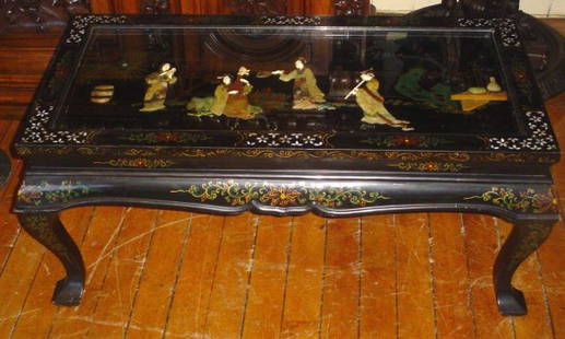 BLK LAQ & MOP ORIENTAL COFFEE TABLE 13733: Black Lacquer and Mother of Pearl coffee table with painted details and two dimensional figural top scene protected by glass. LOT # 13733 Dimensions: 18" H x 42" W x 22" D Age: 1900. Material: Wood