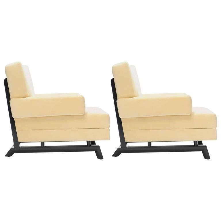 Pair of Paul Laszlo Club Chairs: A wonderful pair of Paul Laszlo club chairs for Brown and Saltman of California. On the Laszlo iconic 'sled base and tapper foot,' the chairs are done in a cream fabric and the frames have been eboniz