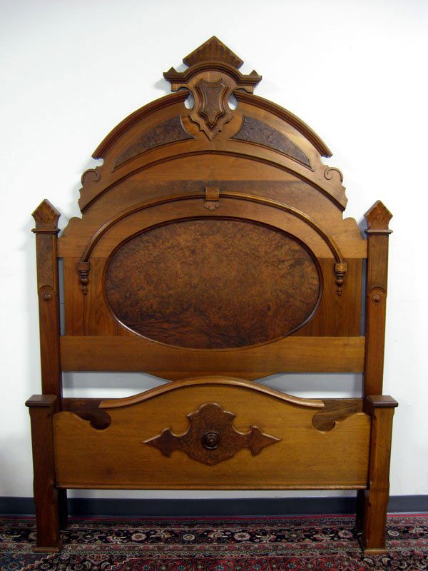 Victorian bed. Walnut with applied carvings and la: Victorian bed. Walnut with applied carvings and large oval burl panel in headboard. Ca 1865. Older refinish and minor repairs. Appropriate age wear. 96''h x 60''w. $300-500