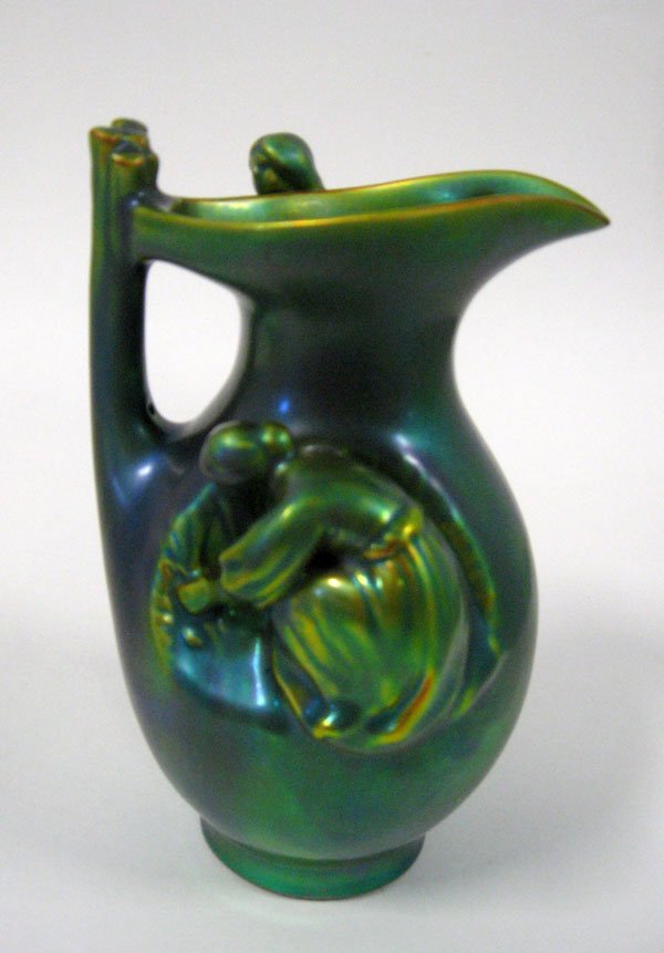 Zsolnay green Eosin pitcher with women sitting and: Zsolnay green Eosin pitcher with women sitting and standing on the side. Tiny flakes on base edge. Good condition. Appropriate age wear. 6 1/4''h. $100-150