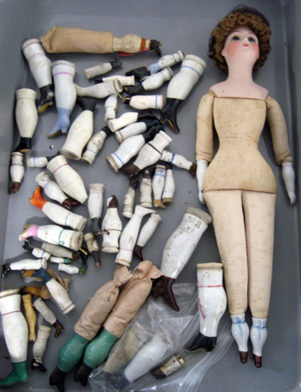 Misc. lot of antique china head doll, legs. One old bod: Misc. lot of antique china head doll, legs. One old body with repro. head. Misc. lot of antique china and Bisque legs for china head or Parian type dolls. China cloth body chip at hand on doll, repro.