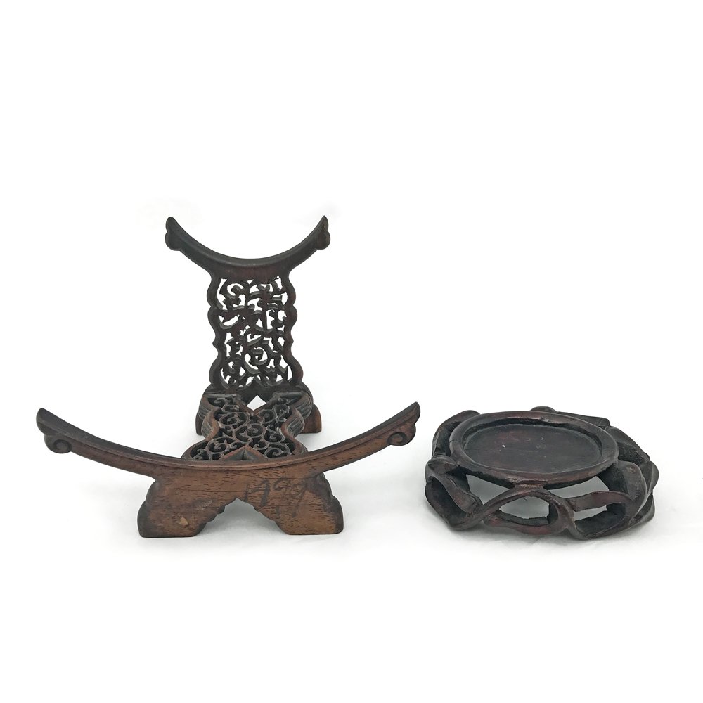 A Pair of Chinese Carved Wooden Stands: A pair of 19th century Chinese carved wooden stands. One stand is carved for a bowl or vase and stamped "China" on the base, the other carved for a plate and with extensive ruyi decoration. Dimensions