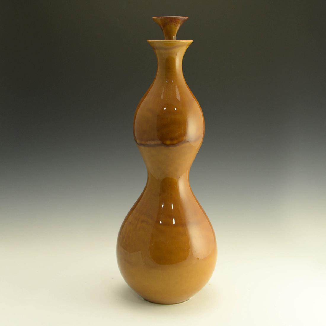 Rare Zeisel Hyalyn Gold Wine Bottle/Vase: Eva Zeisel, a rare Wine Bottle-Vase with Cork-Lined Stopper in Gold glaze, High Fashion, Hyalyn Porcelain, Hickory, NC, 1964. Z 20 and USA molded in paste on underside. Porcelain. Height: 16 7/8 in. (