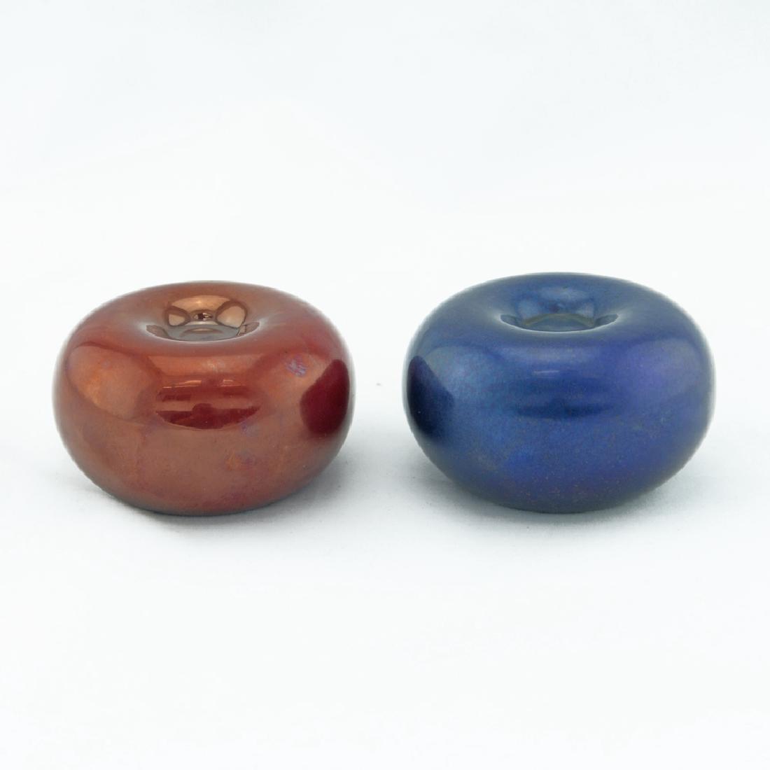 Pair Zeisel Zsolnay Eosin Candleholders: Eva Zeisel, Two apple- or plum-shaped Candleholders, designed 1983, the undersides stamped with the factoryÂ’s mark and Eva Zeisel, the first with 1st Ed OC 99 in white, the second with a price tag