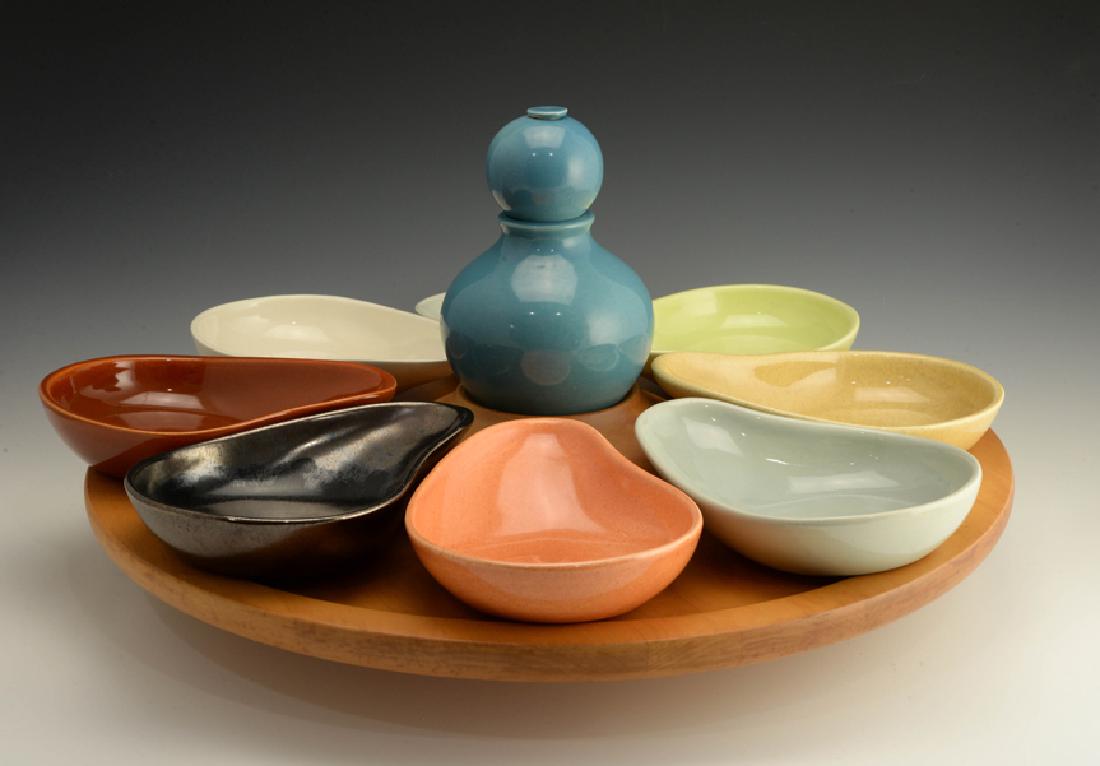Eva Zeisel, Rare Town & Country Lazy Susan Set: Eva Zeisel, a rare complete Lazy Susan Set comprising a Condiment or Mustard Jar, eight Relish Dishes, and a wood Lazy Susan with wood stand for the Condiment Jar, Town and Country, Red Wing Potteries