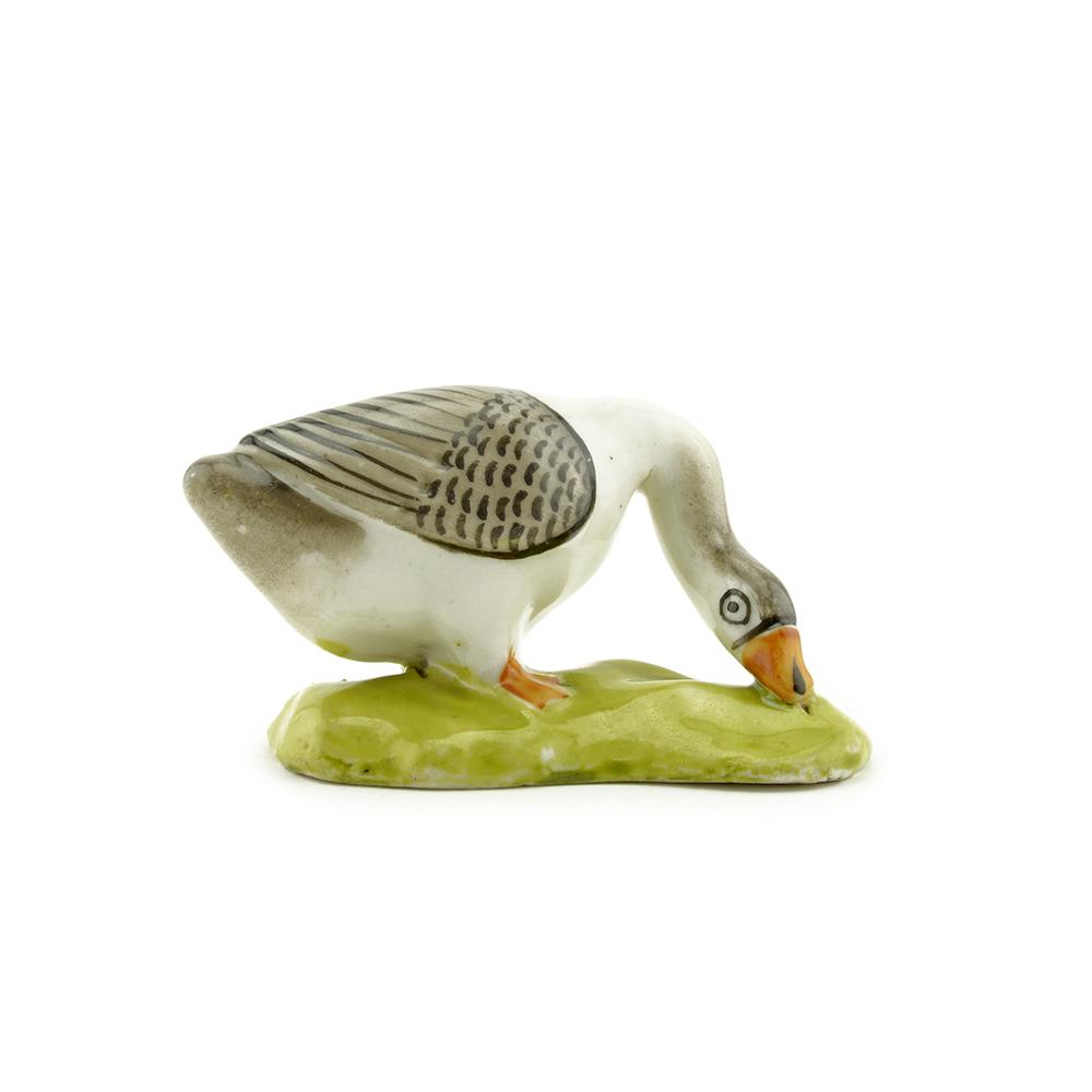 Russian Early Kuznetsov Brothers porcelain goose: A Russian porcelain figure of a goose, Kuznetsov Brothers Manufactory, Novokharitonovo, circa 1850. The simple glazed porcelain figure of a goose on a shaped vase inspired by folk ceramics. Stamped on