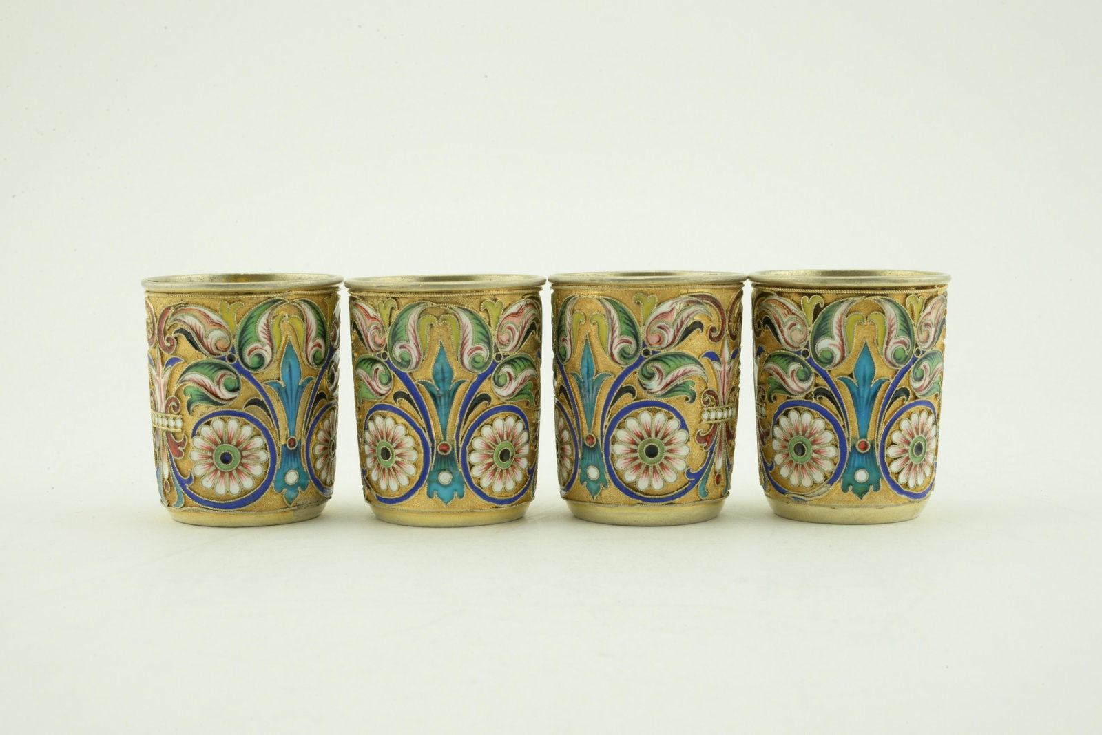 Set of 4 Russian silver enamel beakers: A set of 4 Russian silver gilt and shaded cloisonne enamel beakers, Maria Semenova, Moscow, circa 1895. Of tapering form, the beakers decorated with scrolling floral and foliate motifs against a stipp