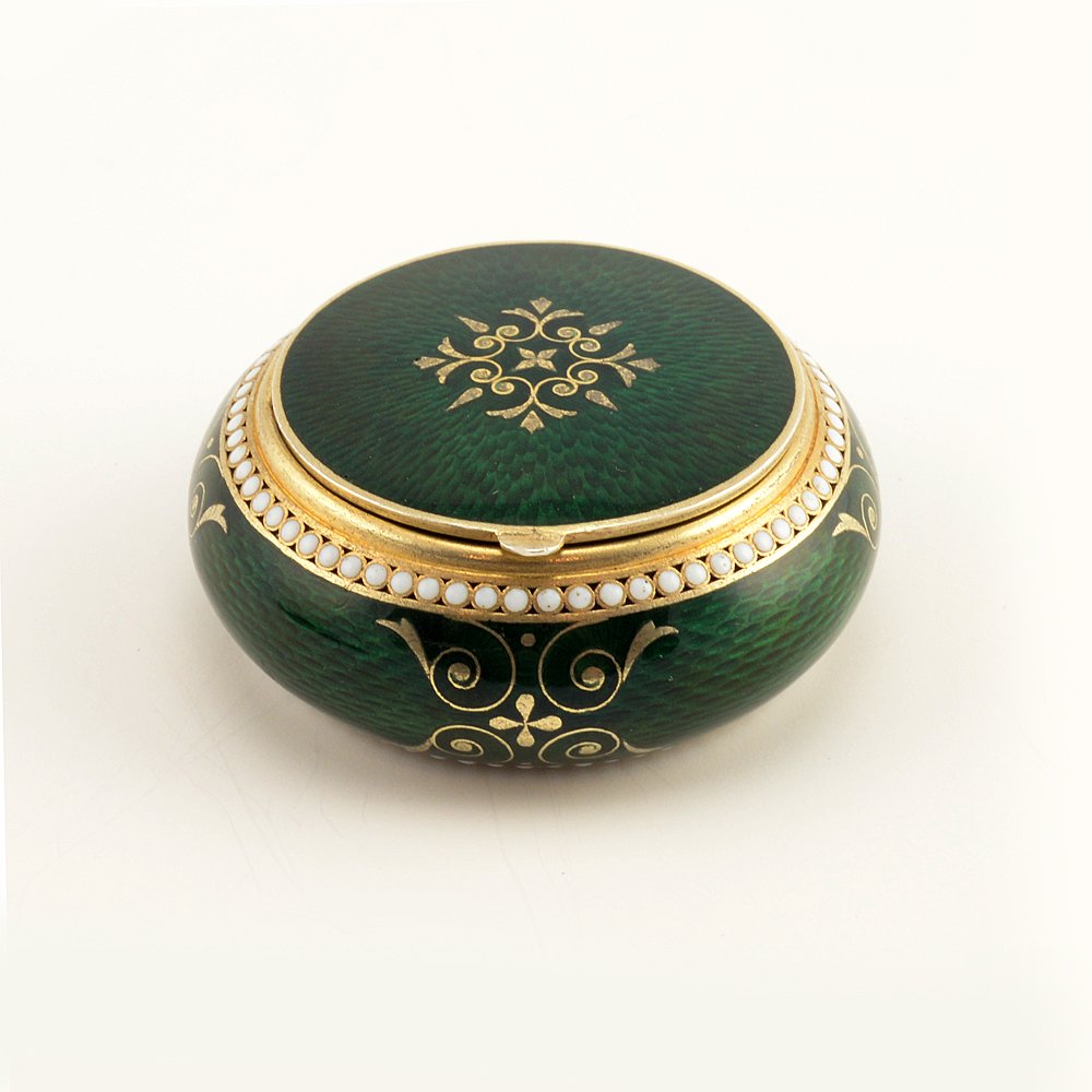 A Grachev guilloché enamel pill box, ca1895: A Russian gilded silver and guilloché enamel pill box, Grachev Brothers, ST Petersburg, circa 1895. The circular box of cushion form, enameled in translucent emerald green over a textured engine-turn
