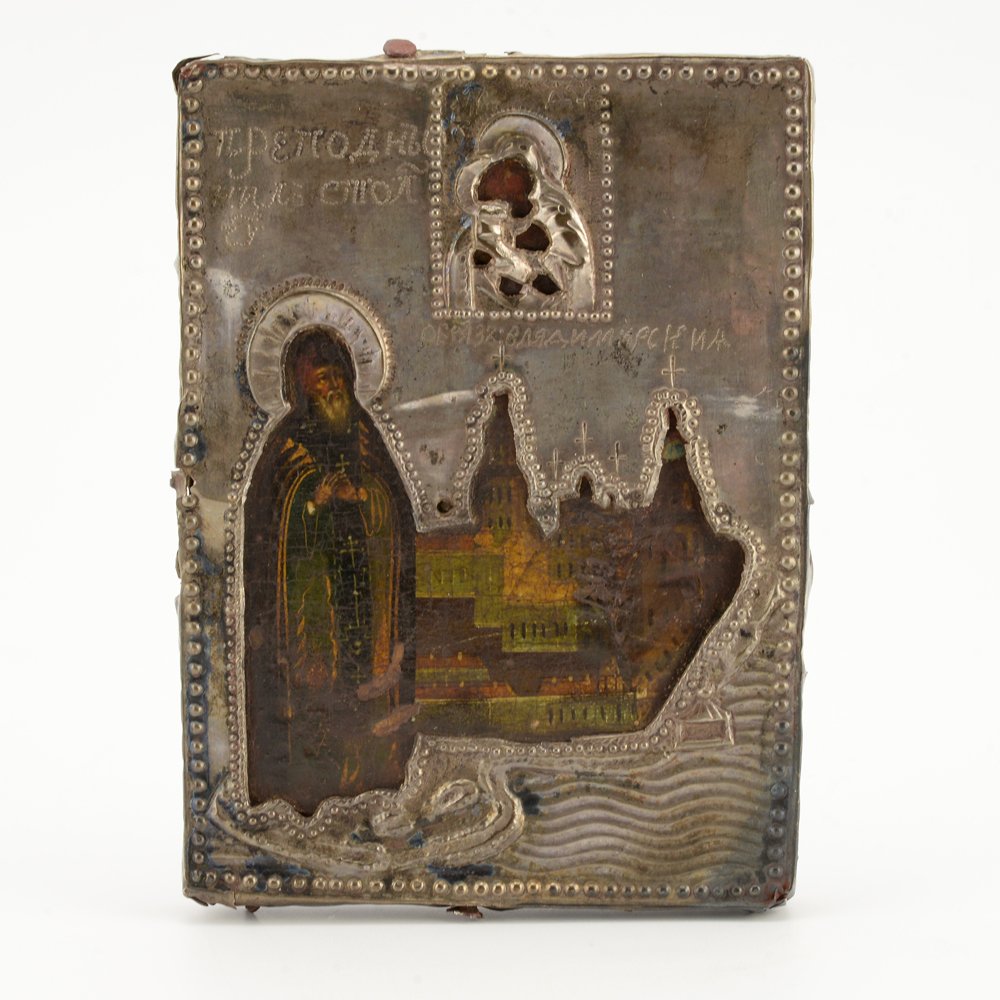 Icon of St. Nil Stolbenskii with silver cover, 19thc.: The icon painted on wood, the Venerable Nil Stolbenskii shown at full length at left wearing monastic robes indicating the highest level of spiritual excellence known as the Great Schema, in backgroun
