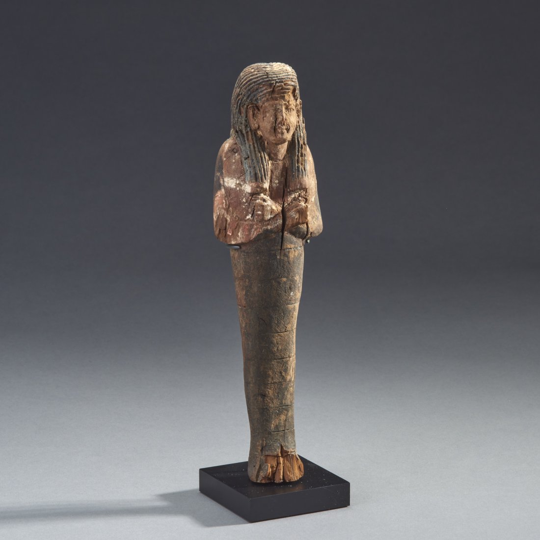 Wooden Egyptian Shabti: Ancient Egypt, New Kingdom, 18th-20th Dynasty, 1558-1085 BC. A sizeable wooden ushabti, well-carved and with traces of polychrome. Custom base. Purchased at Fortuna Gallery,NYC 6/9/04. Height without 
