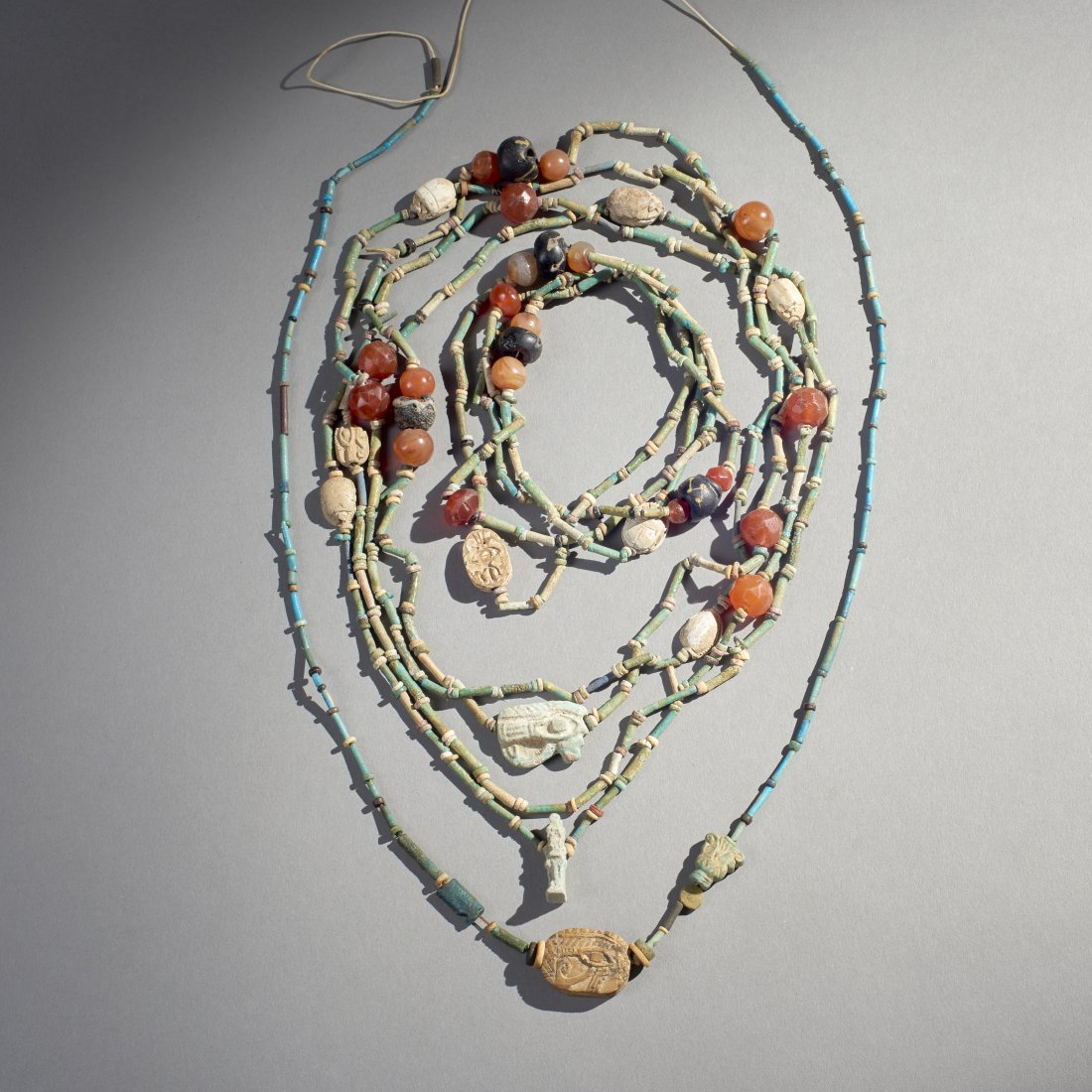 Lot of Ancient Egyptian Beads: Egypt, ca. 1st millennium BC. Lot of ancient beads, consisting of four strung necklaces featuring faceted carnelian and faience elements. Provenance: Old Connecticut estate. Longest: 42 inches / 106.7