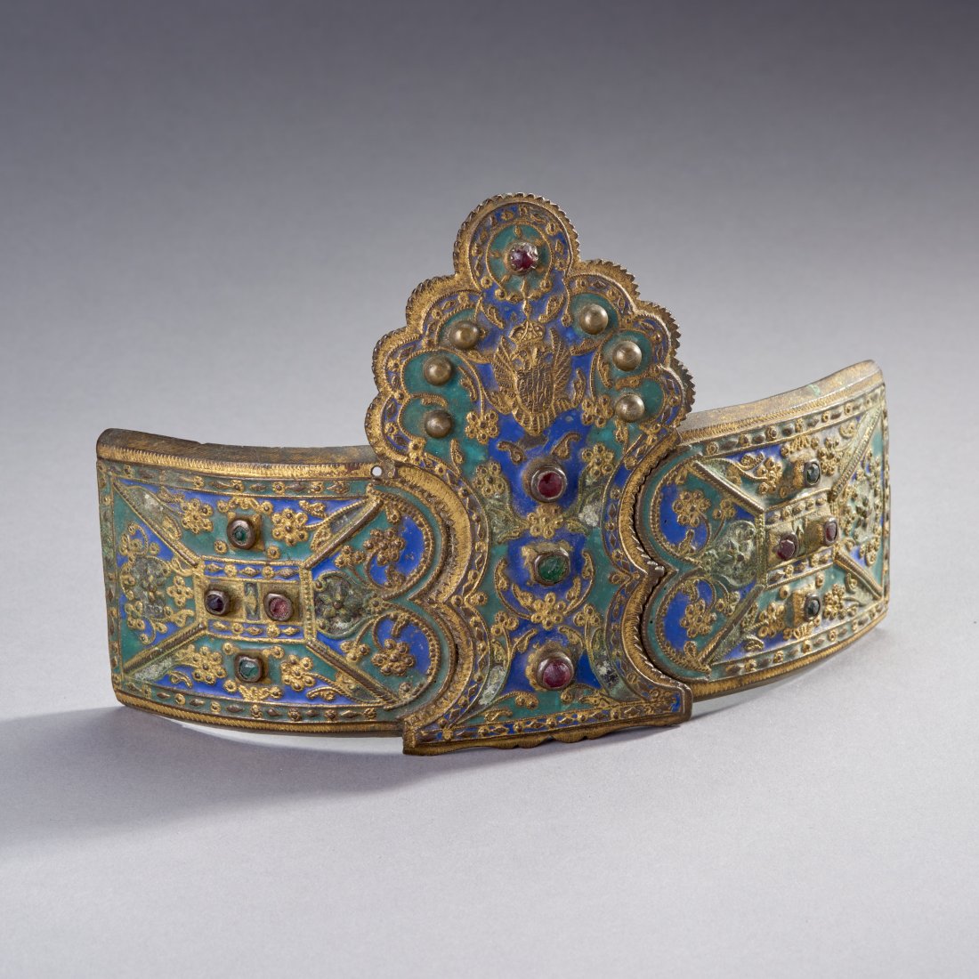 Large Early Russian Belt Buckle: Likely Russia or Eastern Europe, ca. 18th century or earlier. A substantial two-piece gilt bronze belt buckle richly enameled in blue and green and with "jewel" embedments, surmounted a crowned double
