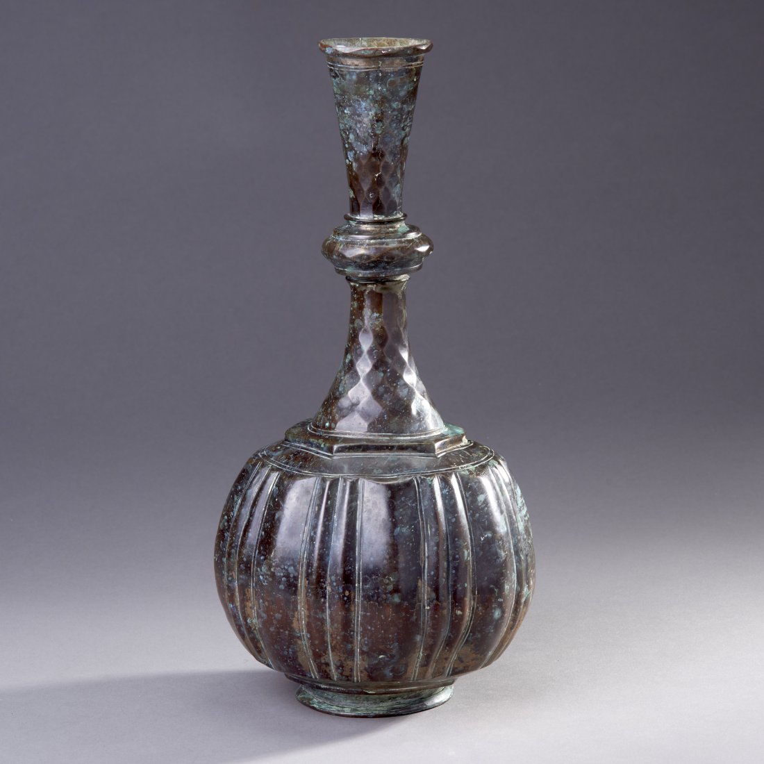 Large Middle Eastern Copper Vase: Middle East, ca. 18th-19th century. Large copper alloy vase. A very fine gilded and hammered (not cast) bottle vase (Surahi) of large proportions, the neck with intricate faceting and the body with co